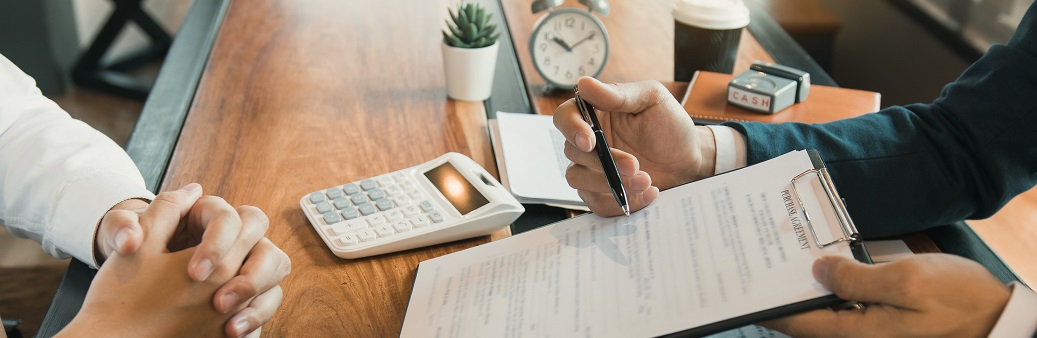 Agents are using pens pointing to contracts and are being explai